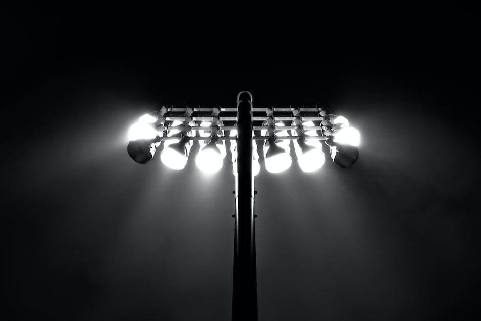 Image depicting floodlights illuminating a large sports arena during a nighttime event